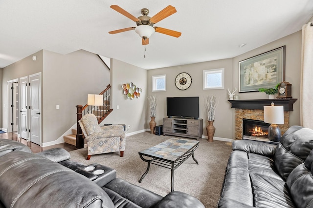 14143 Ailesbury Ave, Rosemount, MN 55068 - carpeted living area featuring stairway, a stone fireplace, and ceiling fan