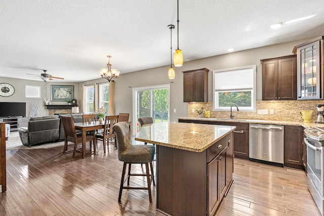 14143 Ailesbury Ave, Rosemount, MN 55068 - kitchen featuring stainless steel appliances, dark brown cabinets, light wood-style flooring, tasteful backsplash, and a textured ceiling