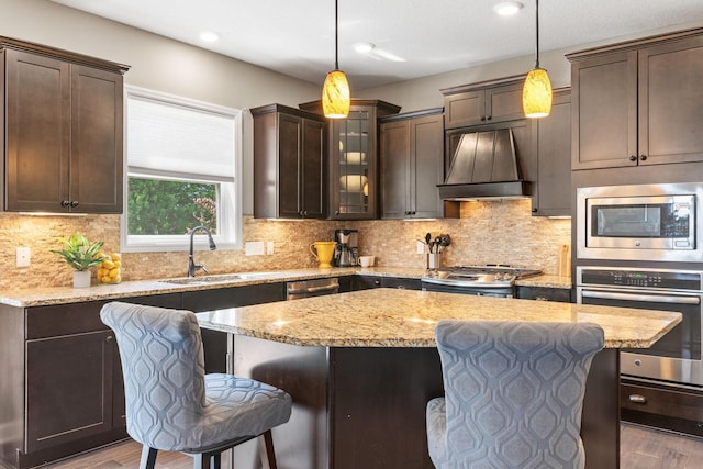 14143 Ailesbury Ave, Rosemount, MN 55068 - kitchen featuring appliances with stainless steel finishes, custom range hood, a kitchen bar, dark brown cabinets, and wood finished floors