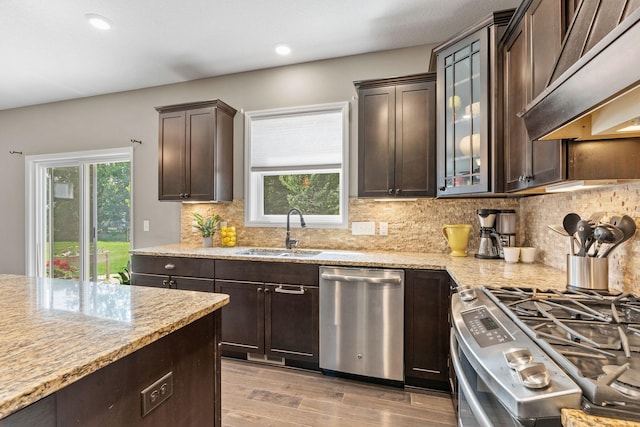 14143 Ailesbury Ave, Rosemount, MN 55068 - kitchen featuring appliances with stainless steel finishes, exhaust hood, dark brown cabinetry, light stone counters, and recessed lighting