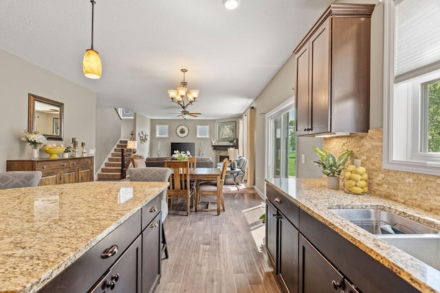 14143 Ailesbury Ave, Rosemount, MN 55068 - kitchen with a chandelier, hanging light fixtures, light wood-style floors, open floor plan, and decorative backsplash