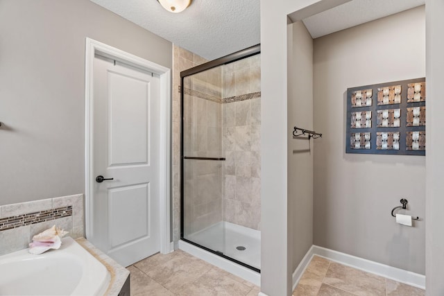 14143 Ailesbury Ave, Rosemount, MN 55068 - bathroom with a shower stall, a bath, tile patterned flooring, and a textured ceiling