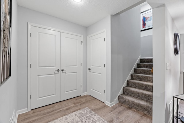 14143 Ailesbury Ave, Rosemount, MN 55068 - foyer entrance featuring light wood-style floors, stairway, and a textured ceiling