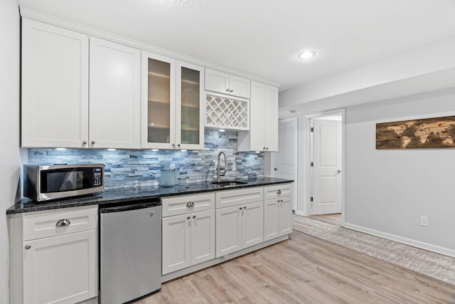 14143 Ailesbury Ave, Rosemount, MN 55068 - kitchen featuring stainless steel microwave, fridge, tasteful backsplash, white cabinets, and light wood finished floors