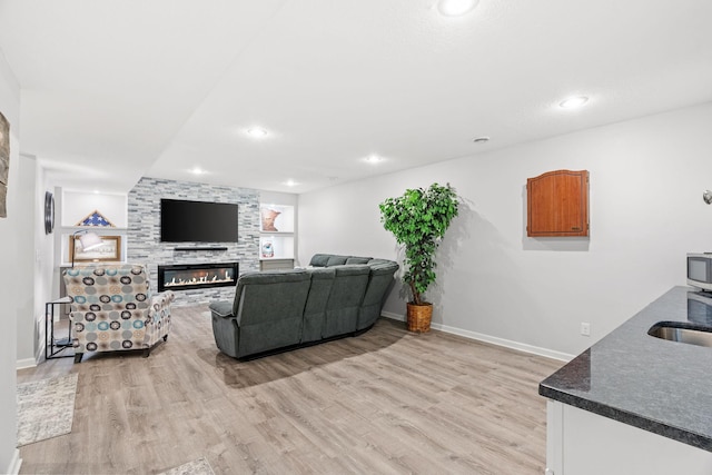 14143 Ailesbury Ave, Rosemount, MN 55068 - living area featuring light wood-type flooring, a large fireplace, and recessed lighting