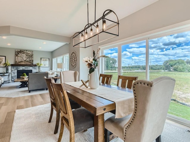 68 143rd Ave NW, Andover, MN 55304 - dining room with light wood-type flooring, a fireplace, and a chandelier