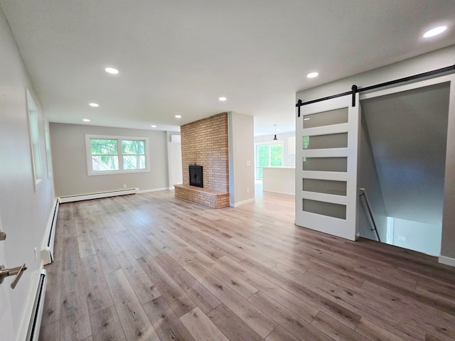 2710 Garden Ln, Mound, MN 55364 - unfurnished living room featuring a barn door, baseboard heating, a baseboard heating unit, wood finished floors, and recessed lighting
