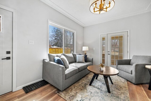 2808 32nd Ave S, Minneapolis, MN 55406 - living room featuring wood finished floors, a chandelier, and baseboards