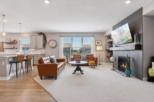 515 Goldenrod Trl, Waconia, MN 55387 - living room with a fireplace, light wood finished floors, recessed lighting, and baseboards