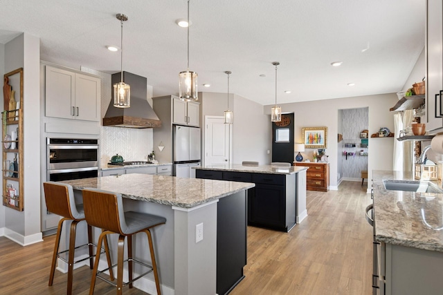 515 Goldenrod Trl, Waconia, MN 55387 - kitchen with wall chimney exhaust hood, a kitchen island, freestanding refrigerator, a sink, and gas cooktop