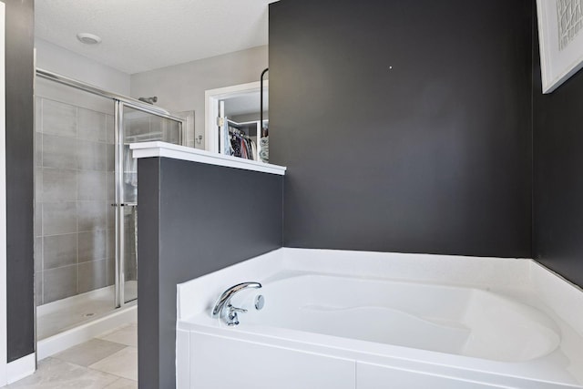 515 Goldenrod Trl, Waconia, MN 55387 - bathroom featuring a bath, a walk in closet, a stall shower, and tile patterned floors