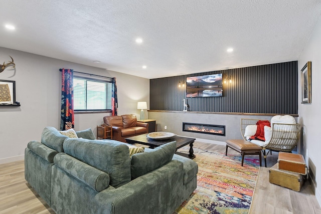 515 Goldenrod Trl, Waconia, MN 55387 - living room with wood finished floors, a textured ceiling, recessed lighting, a glass covered fireplace, and baseboards