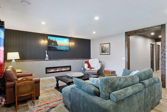 515 Goldenrod Trl, Waconia, MN 55387 - living room featuring wood finished floors, a glass covered fireplace, recessed lighting, a textured ceiling, and baseboards
