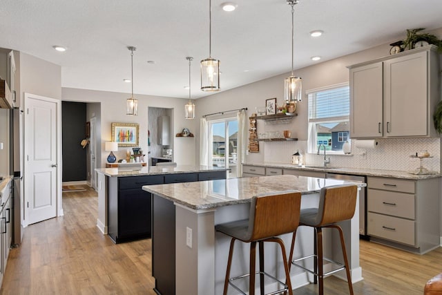 515 Goldenrod Trl, Waconia, MN 55387 - kitchen featuring a kitchen island, dishwashing machine, light wood-style flooring, backsplash, and gray cabinets