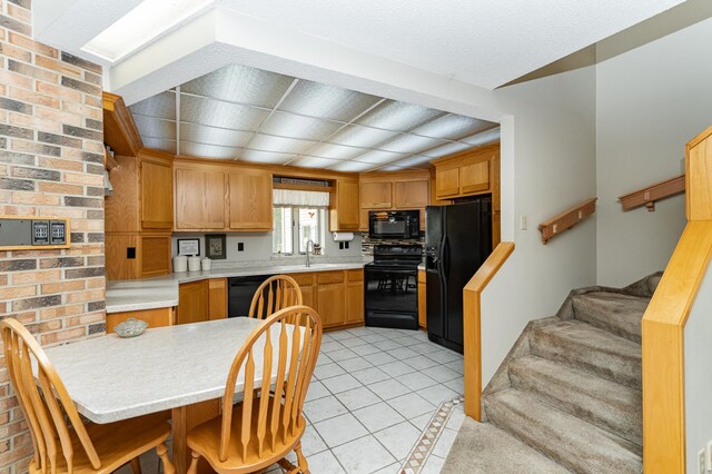 8706 Town Hall Rd NW, Byron, MN 55920 - kitchen with black appliances, a sink, light countertops, and light tile patterned floors