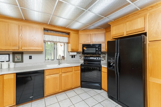8706 Town Hall Rd NW, Byron, MN 55920 - kitchen with black appliances, a sink, light countertops, light tile patterned floors, and light brown cabinets