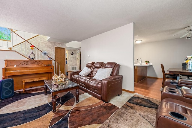 8712 Cottonwood Ln, Maple Grove, MN 55369 - living room featuring a textured ceiling, stairway, wood finished floors, and baseboards