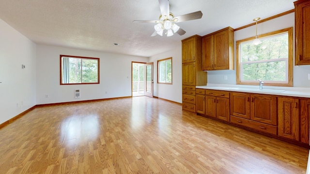 21341 County 50, Park Rapids, MN 56470 - kitchen with a sink, brown cabinets, a ceiling fan, and light wood-type flooring