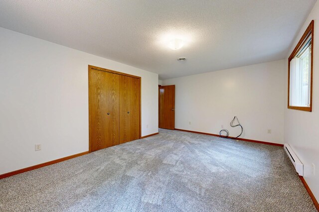 21341 County 50, Park Rapids, MN 56470 - unfurnished bedroom featuring baseboard heating, carpet flooring, a closet, a textured ceiling, and baseboards