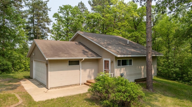 21341 County 50, Park Rapids, MN 56470 - view of side of property featuring a shingled roof, a garage, a lawn, and view of scattered trees