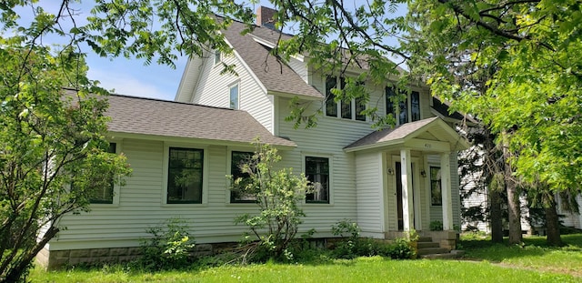 420 Spring St, River Falls, WI 54022 - rear view of house with a shingled roof and a chimney