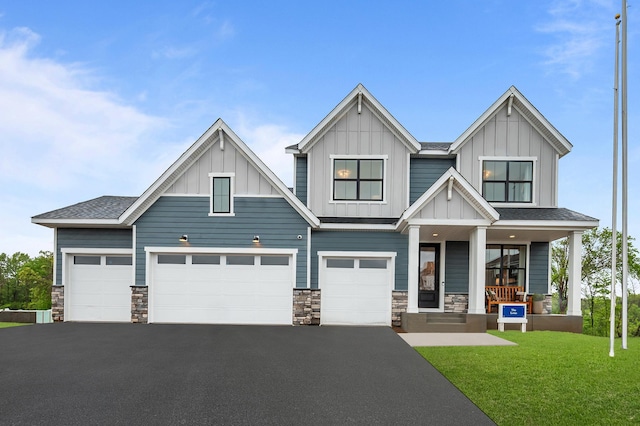 14810 106th Ave N, Maple Grove, MN 55369 - view of front of property with asphalt driveway, board and batten siding, a porch, and stone siding