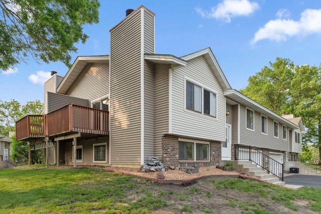 583 97th Ln NE, Blaine, MN 55434 - view of side of property featuring a chimney, brick siding, a garage, a deck, and driveway