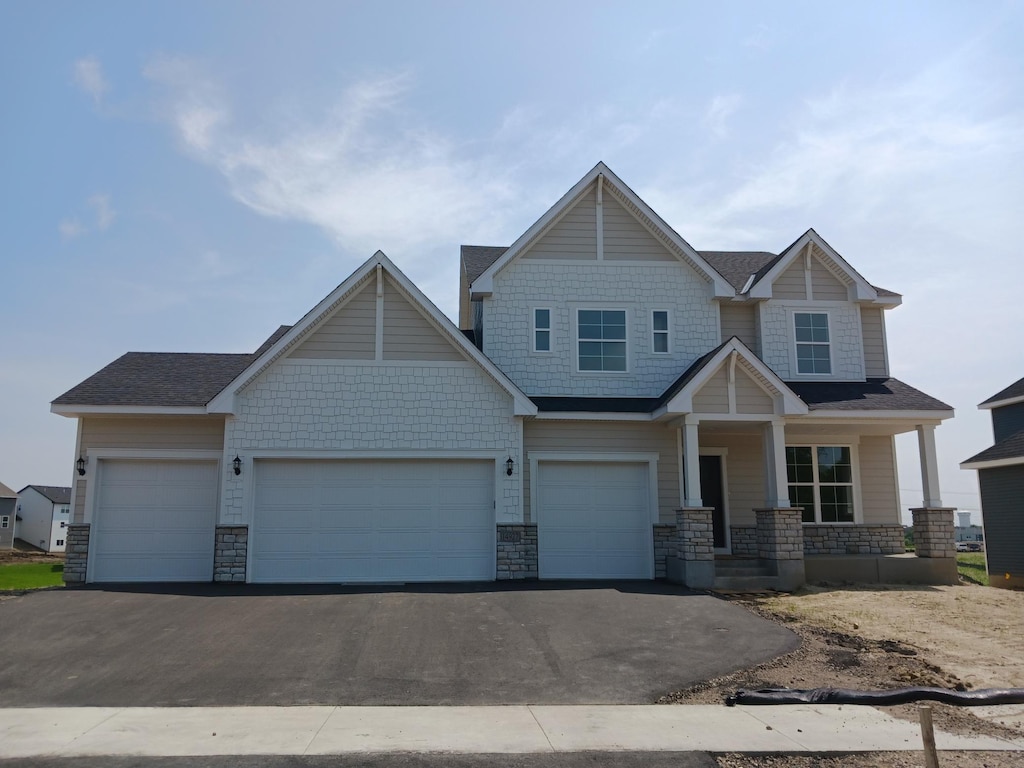 14927 106th Ave N, Maple Grove, MN 55369 - craftsman-style house featuring driveway, a porch, stone siding, and a garage