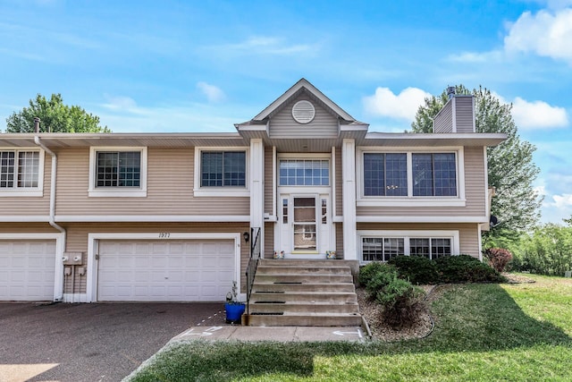 1977 Granite Ave N, Oakdale, MN 55128 - split foyer home featuring a chimney, a garage, and driveway