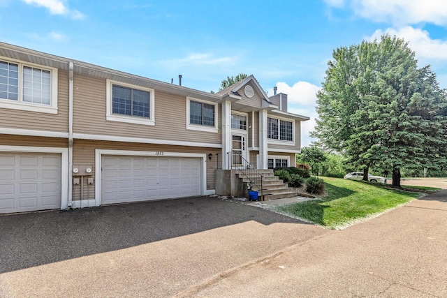 1977 Granite Ave N, Oakdale, MN 55128 - view of front facade featuring a chimney, driveway, and an attached garage