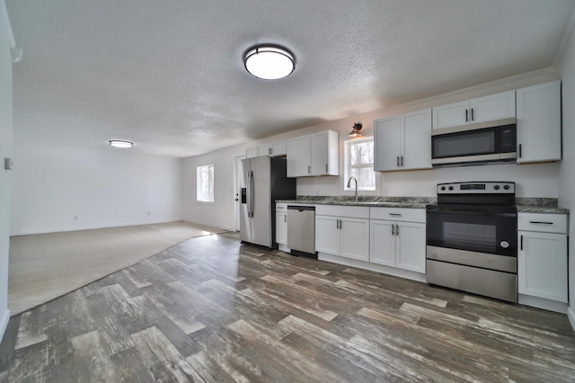 32736 203rd Ave, Clarissa, MN 56440 - kitchen featuring appliances with stainless steel finishes, healthy amount of natural light, dark wood finished floors, a textured ceiling, and open floor plan