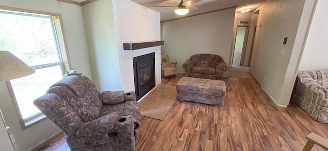 68005 County Road 3, Bandon Twp, MN 55332 - living room featuring wood finished floors, a large fireplace, ceiling fan, plenty of natural light, and ornamental molding