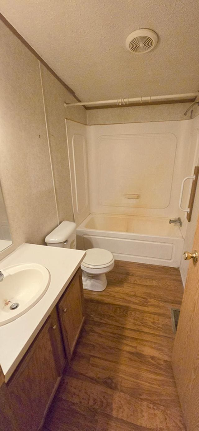 68005 County Road 3, Bandon Twp, MN 55332 - full bathroom with vanity, bathing tub / shower combination, wood finished floors, toilet, and a textured ceiling