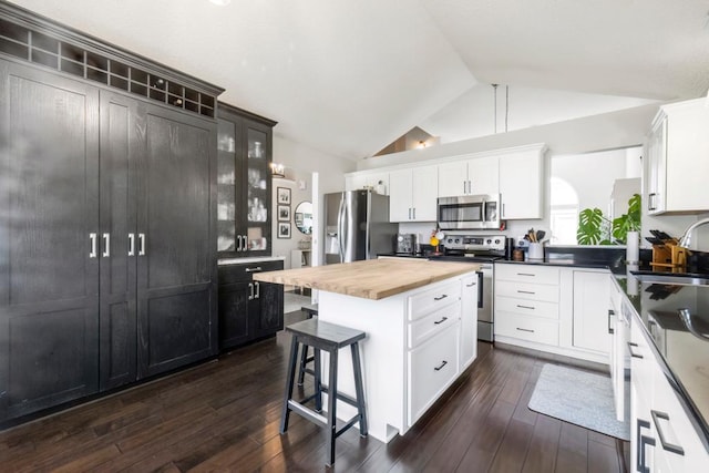 4417 Braddock Trl, Eagan, MN 55123 - kitchen with stainless steel appliances, vaulted ceiling, wooden counters, a kitchen bar, and a sink