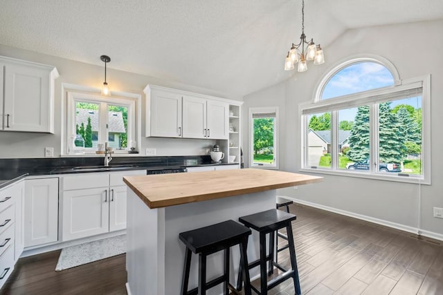 4417 Braddock Trl, Eagan, MN 55123 - kitchen with butcher block counters, a sink, vaulted ceiling, white cabinets, and a breakfast bar area