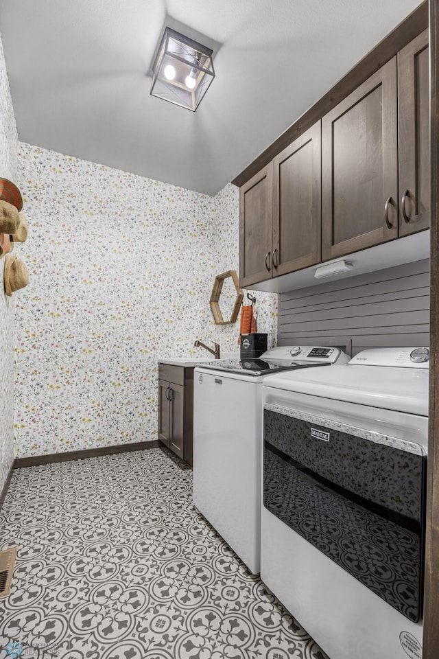 2781 Golden Ln S, Fargo, ND 58104 - laundry area featuring cabinet space, washing machine and dryer, wallpapered walls, and baseboards