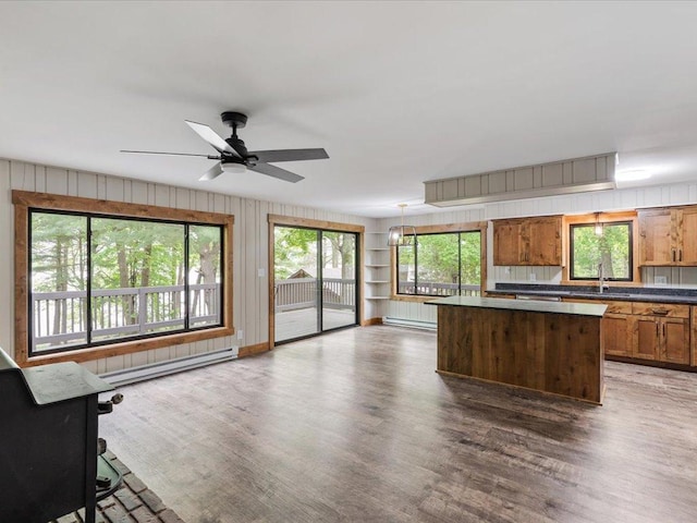 15622 Sand Beach Park, Bay Lake Twp, MN 56444 - kitchen with baseboard heating, a sink, a kitchen island, plenty of natural light, and wood walls