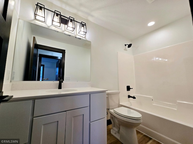 1109 9th Ave SE, Waseca, MN 56093 - full bathroom with toilet, wood finished floors, vanity, and bathtub / shower combination