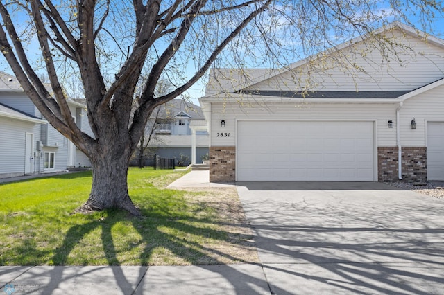 2831 Wheatland Dr S, Fargo, ND 58103 - view of front of home with brick siding, a garage, concrete driveway, and a front yard
