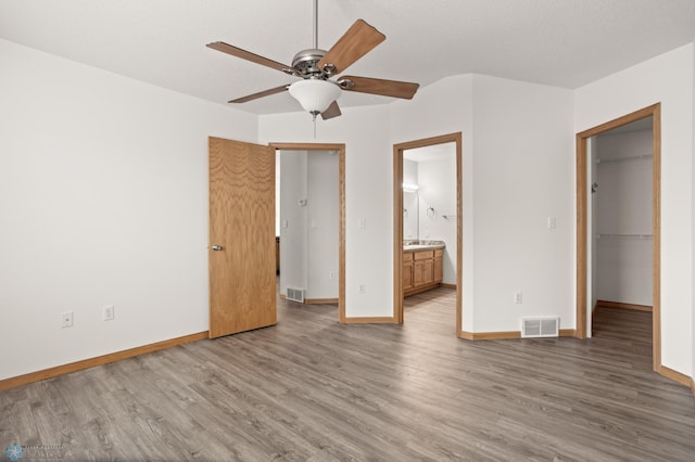 2831 Wheatland Dr S, Fargo, ND 58103 - unfurnished bedroom with wood finished floors, a spacious closet, and baseboards