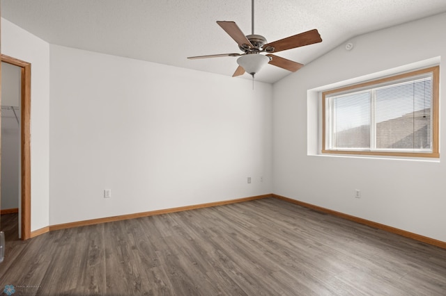 2831 Wheatland Dr S, Fargo, ND 58103 - spare room with wood finished floors, a ceiling fan, lofted ceiling, and baseboards