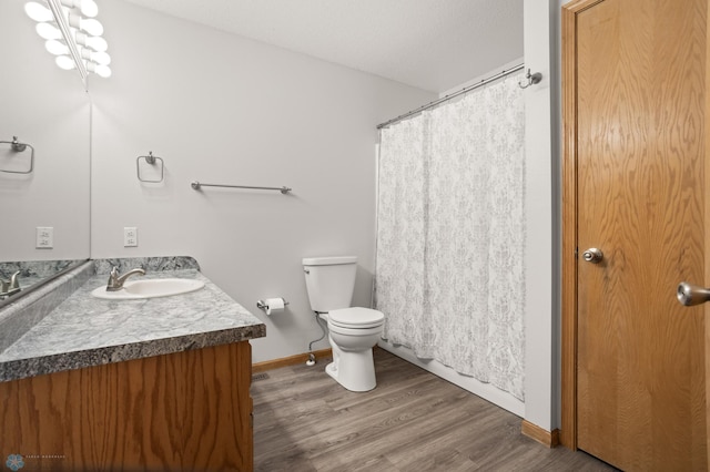 2831 Wheatland Dr S, Fargo, ND 58103 - bathroom with vanity, toilet, wood finished floors, baseboards, and a shower with curtain