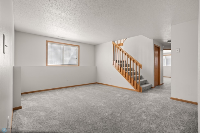 2831 Wheatland Dr S, Fargo, ND 58103 - carpeted spare room featuring stairs, a textured ceiling, and baseboards