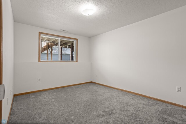 2831 Wheatland Dr S, Fargo, ND 58103 - empty room featuring carpet flooring, a textured ceiling, and baseboards