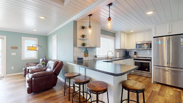27096 Little Floyd Lake Rd Unit 1, Detroit Lakes, MN 56501 - kitchen featuring stainless steel appliances, a peninsula, a breakfast bar area, white cabinets, and a sink