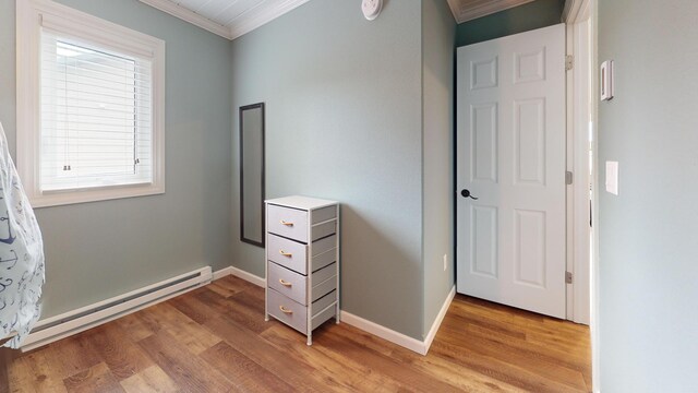 27096 Little Floyd Lake Rd Unit 1, Detroit Lakes, MN 56501 - unfurnished bedroom featuring crown molding, light wood-type flooring, multiple windows, a baseboard heating unit, and baseboards