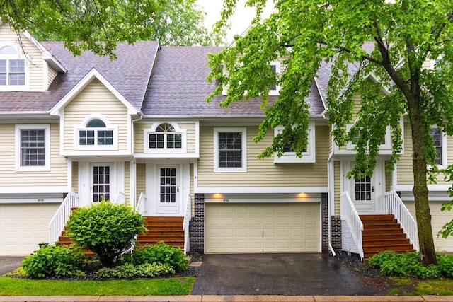 4906 Bayswater Rd, Minnetonka, MN 55345 - view of front of house with an attached garage, driveway, roof with shingles, and stairway