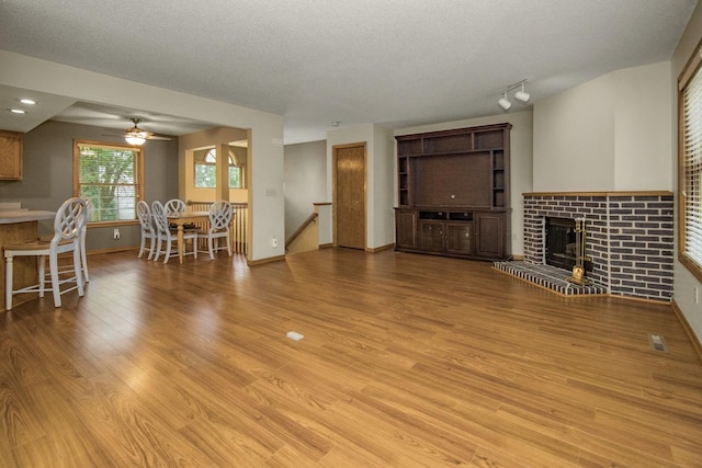 4906 Bayswater Rd, Minnetonka, MN 55345 - living area with a ceiling fan, a fireplace, light wood-style floors, a textured ceiling, and baseboards