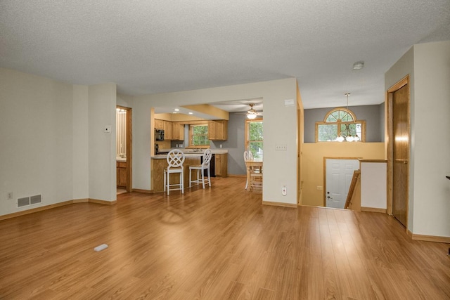 4906 Bayswater Rd, Minnetonka, MN 55345 - living area featuring light wood-style floors, a textured ceiling, ceiling fan, and baseboards
