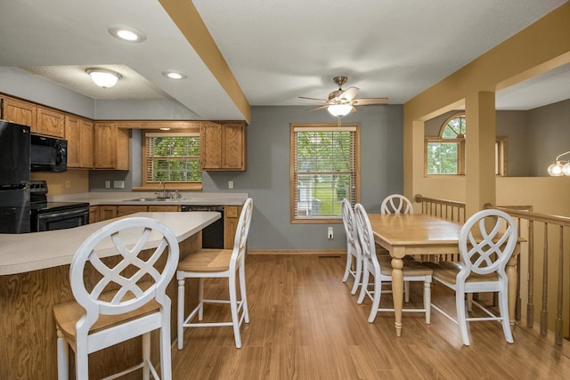 4906 Bayswater Rd, Minnetonka, MN 55345 - kitchen featuring black appliances, brown cabinetry, light countertops, a sink, and a ceiling fan